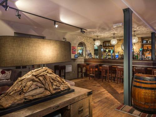 a room with a bar and a table with a barrel at The Admiral Rodney Hotel, Horncastle, Lincolnshire - The Coaching Inn Group in Horncastle