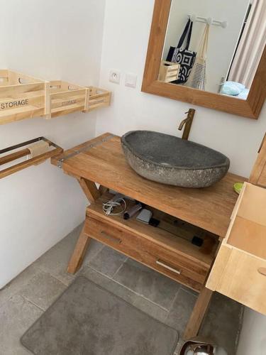 La salle de bains est pourvue d'un lavabo en pierre sur une table en bois. dans l'établissement Maison familiale en bord de mer, à Saint-Nazaire