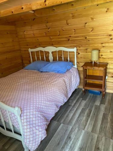 une chambre avec un lit dans une cabane en rondins dans l'établissement Maison familiale en bord de mer, à Saint-Nazaire