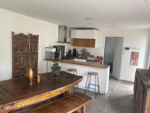 - une cuisine avec une table en bois et un comptoir dans l'établissement Maison familiale en bord de mer, à Saint-Nazaire