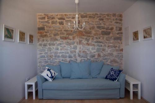 a blue couch in a room with a brick wall at Apartment Salvia - Stivan, Cres - 900 m to Merascica beach in Štivan
