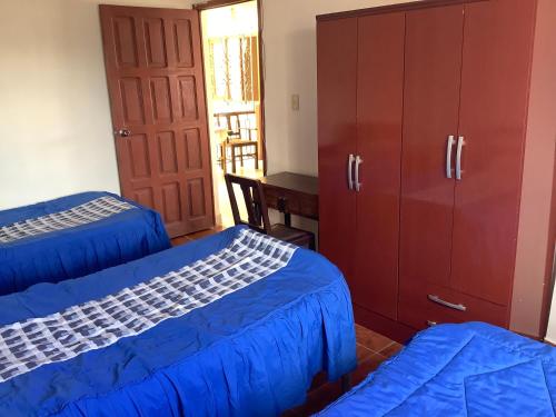 a bedroom with two beds and a dresser at Rovira Viajes y Turismo in Tupiza