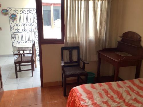 a bedroom with a bed and a desk and a chair at Rovira Viajes y Turismo in Tupiza