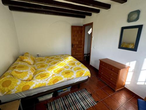 a bedroom with a bed and a dresser and a mirror at Romantic house in Sedella in Sedella