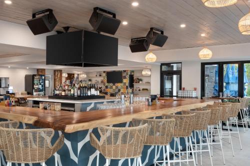 a bar with wicker chairs and a long wooden counter at The Wave at Marblehead in Marblehead