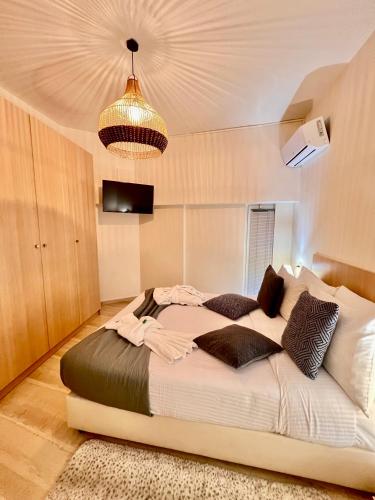 a bedroom with a large bed and a chandelier at Central Studio Semi-basement in Heraklio