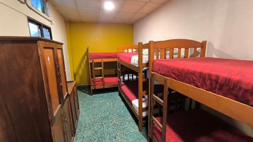 a room with three bunk beds and a dresser at Flying Dog Hostel Iquitos in Iquitos