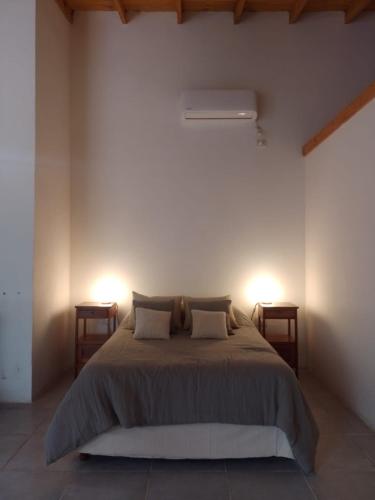 a bedroom with a large bed with two night stands at Casa en Villa Ventana in Villa Ventana