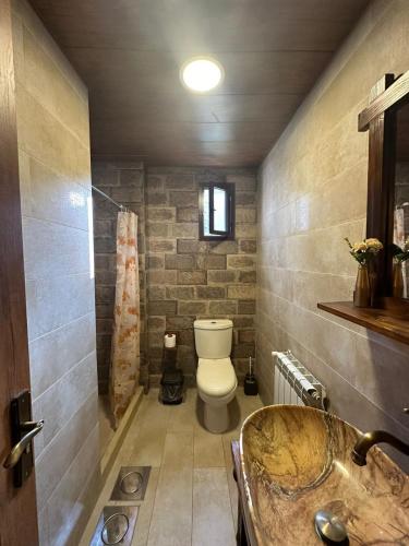 a bathroom with a toilet and a sink and a tub at Rokwood faraya in Ash Sha‘rah