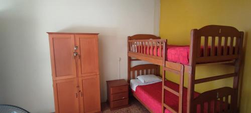 a bedroom with two bunk beds and a dresser at Flying Dog Hostel Iquitos in Iquitos