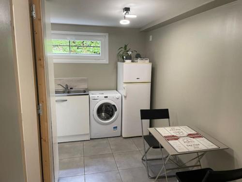 a small kitchen with a washing machine and a table at Appartement terrasse avec vue et parking privé in Louviers