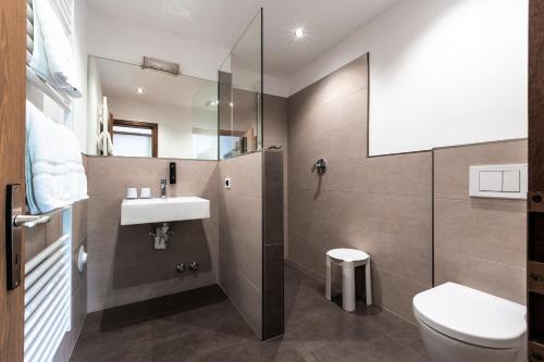 a bathroom with a sink and a toilet at Hotel Zum Löwen - Al Leone in Meltina