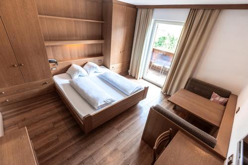 a bedroom with a large bed and a window at Hotel Zum Löwen - Al Leone in Meltina