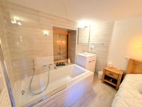 une salle de bain avec une baignoire, une douche et un lavabo dans l'établissement Résidence La Croix De Fer - Appartement entièrement rénové à St Martin de Belleville MAE-4784, à Saint-Martin-de-Belleville