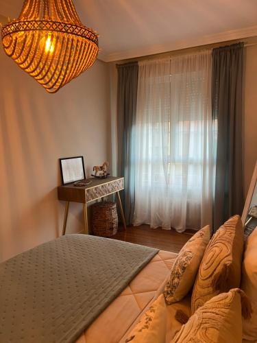a bedroom with a bed and a table with a window at Oviedo Centro- Parking gratuito in Oviedo