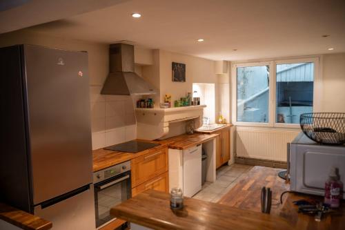 Il comprend une cuisine équipée d'un réfrigérateur en acier inoxydable et une fenêtre. dans l'établissement Chambre individuelle 3, à Ancerville