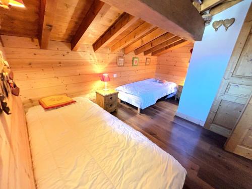 a bedroom with two beds in a wooden room at Chalet De Julie - Bel appartement traditionnel 4 pièces sur 2 niveau pour 6 personnes MAE-3734 in Saint-Martin-de-Belleville