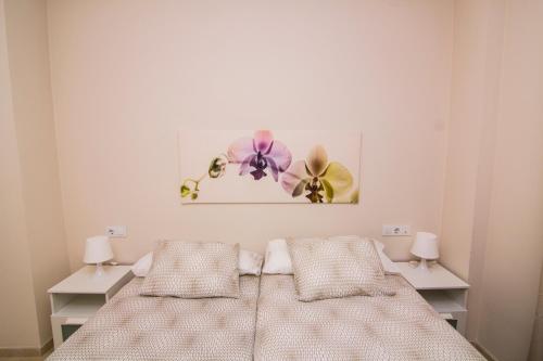 a bedroom with a bed and a painting on the wall at Apartamentos Centro Puerto de Santa Maria in El Puerto de Santa María