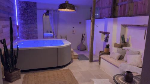 a large bathroom with a tub and a couch at Love room la bohème in Baccarat