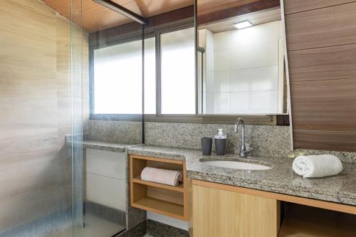 a bathroom with a sink and a mirror at Flat ou Bangalo Luxo Beach Class Beira Mar Muro Alto in Porto De Galinhas