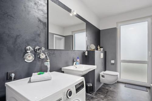 a bathroom with a sink toilet and a mirror at Stilvolle Stadtoase, 116 qm, Parkblick, Wassernah, Parkplatz in Wilhelmshaven