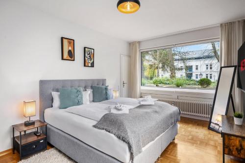a bedroom with a large bed and a window at Stilvolle Stadtoase, 116 qm, Parkblick, Wassernah, Parkplatz in Wilhelmshaven