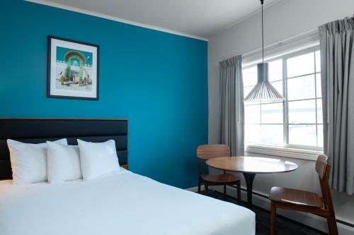 a hotel room with a bed and a table at Sapphire Motel Midtown Bozeman in Bozeman