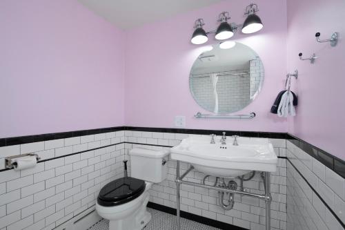 a bathroom with a toilet and a sink and a mirror at Sapphire Motel Midtown Bozeman in Bozeman
