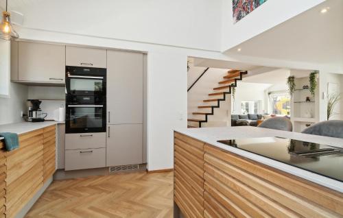 a kitchen with white cabinets and a staircase at Awesome Home In Slagelse With Wifi in Slagelse