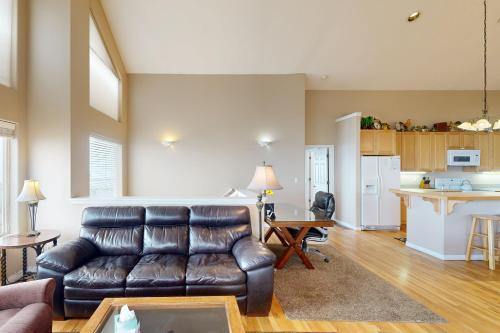 a living room with a leather couch and a kitchen at The Beach House in Lincoln City