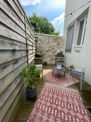 a patio with two rugs and a table and a wall at 23 Lesigne in Lisieux