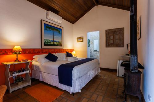 a bedroom with a large bed in a room at Pouso Caminho das Artes in Cunha