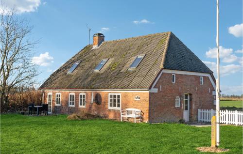 a red brick house with a roof on a green field at Awesome Home In Bredebro With Wifi in Bredebro