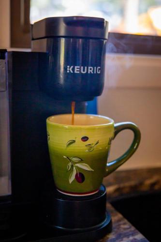 a coffee maker is making a cup of coffee at Peaceful Pine Place Cabin in Pine