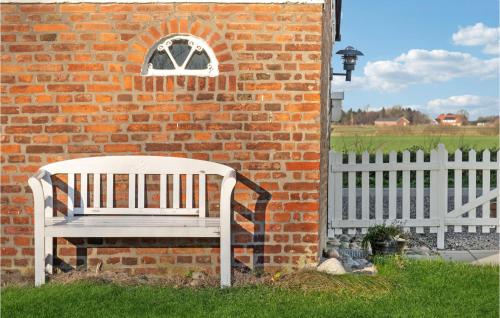 a white bench sitting in front of a brick wall at Awesome Home In Bredebro With Wifi in Bredebro