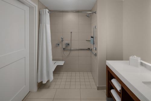 a white bathroom with a shower and a sink at Residence Inn by Marriott Durham Duke University Medical Center Area in Durham