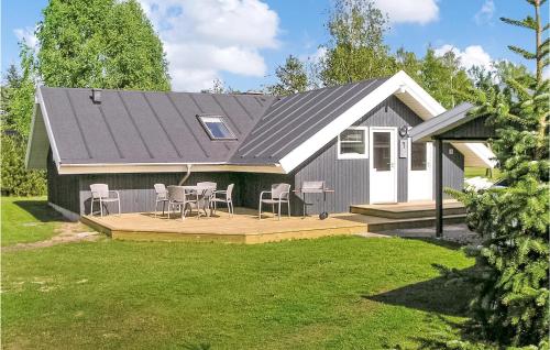 a house with a deck with chairs and a table at Holiday Home Ternevej Ørsted Iii in Kare