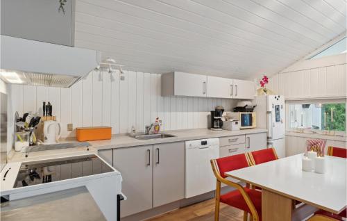 a kitchen with white cabinets and a table and chairs at 2 Bedroom Beautiful Home In Herning in Kølkær