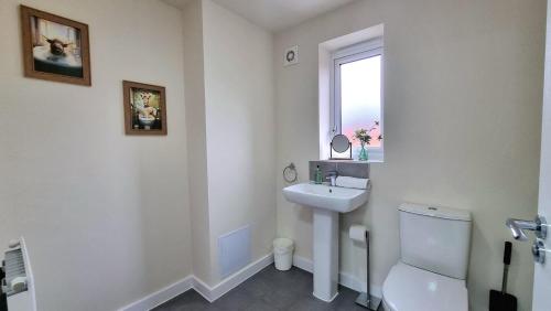 a white bathroom with a sink and a toilet at Modern New Build 3-Storey Home with Parking near Leicester City Centre in Leicester