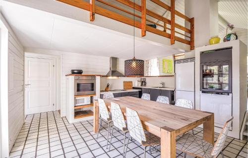 a kitchen with a wooden table and chairs at Cozy Home In Ebeltoft With Sauna in Ebeltoft