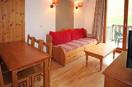 - un salon avec un canapé et des oreillers rouges dans l'établissement Résidence Les Colchiques - 2 Pièces pour 6 Personnes 621, aux Orres