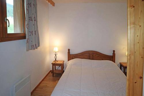 - une chambre avec un lit et 2 tables avec des lampes dans l'établissement Résidence Les Colchiques - 2 Pièces pour 6 Personnes 621, aux Orres