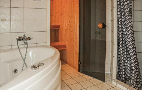a bath tub in a bathroom with a shower at Holiday Home Strandparken Otterup Ix in Otterup