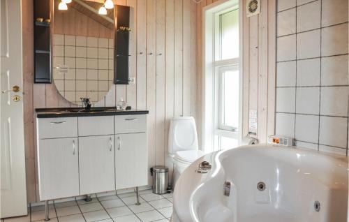 a bathroom with a tub and a toilet and a sink at Holiday Home Strandparken Otterup Ix in Otterup