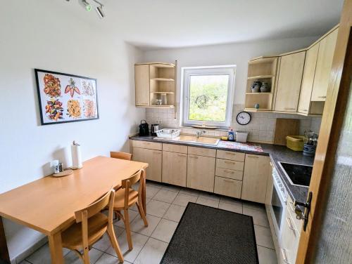 una cucina con un tavolo di legno e un tavolo da pranzo di Moderne und Gemütliche Stadtnahe Wohnung a Hassfurt