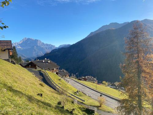 a winding road on a hill with mountains in the background at Casa di Sere in Pieve di Livinallongo