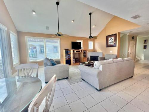 a living room with two couches and a glass table at Cool Change- Sunset Beach- Beachfront- Pet-Friendly in St. George Island