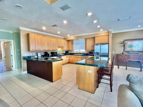 a large kitchen with wooden cabinets and a table at Cool Change- Sunset Beach- Beachfront- Pet-Friendly in St. George Island