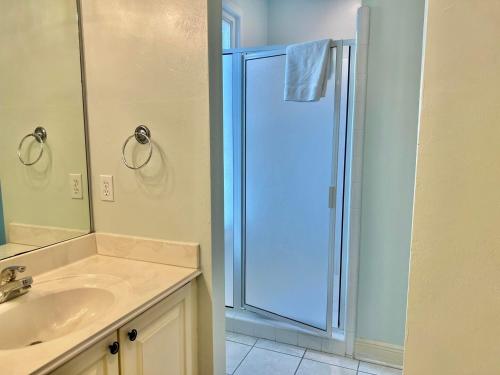 a bathroom with a sink and a glass shower at Cool Change- Sunset Beach- Beachfront- Pet-Friendly in St. George Island