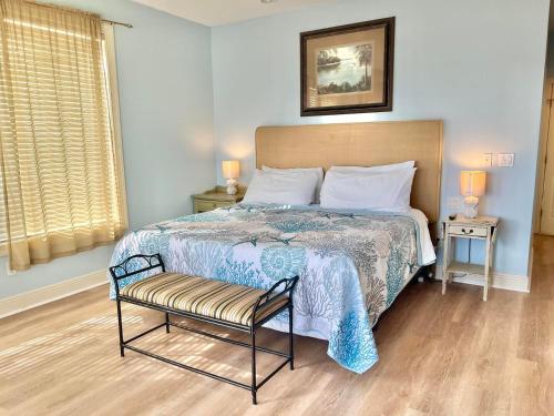 a bedroom with a bed with a chair and a window at Cool Change- Sunset Beach- Beachfront- Pet-Friendly in St. George Island